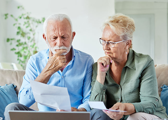 Senior couple reviewing life insurance premium options with a financial advisor.
